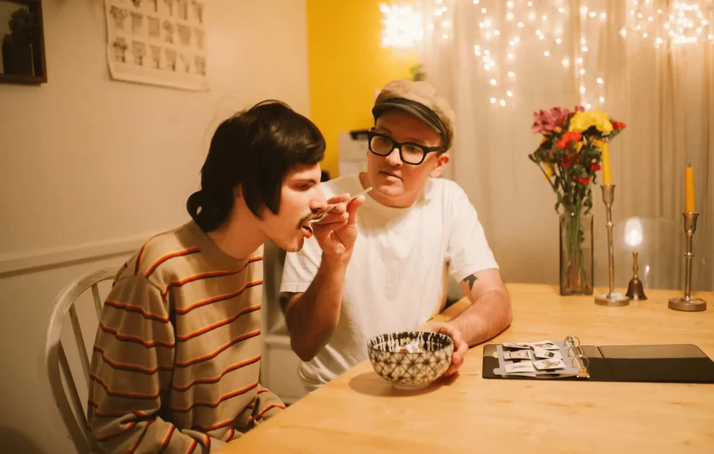 A man receiving assistance with eating breakfast